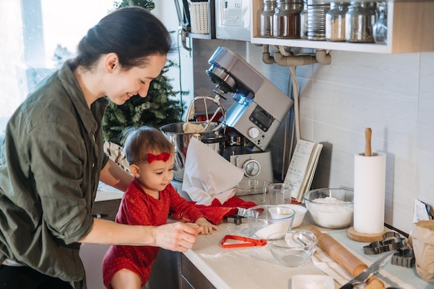 Acogedora Navidad en casa, preparación familiar, postre navideño, madre y bebé, niño pequeño, hija jugar