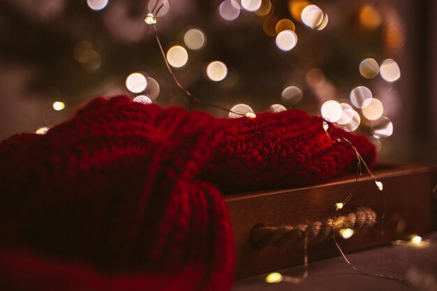 Acogedora tarjeta navideña con un plaid rojo y un árbol decorado en el salón de la casa