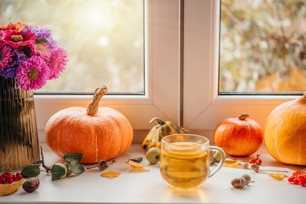 Aconchegante apartamento de outono com uma xícara de chá de limão, abóboras e bolotas