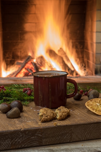 Aconchegante cena antes lareira com esmaltado caneca de chocolate quente, frutas quente e nozes.