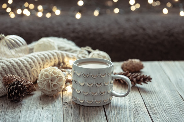 Aconchegante fundo de Natal com uma bela xícara e detalhes de decoração em um fundo desfocado com bokeh.