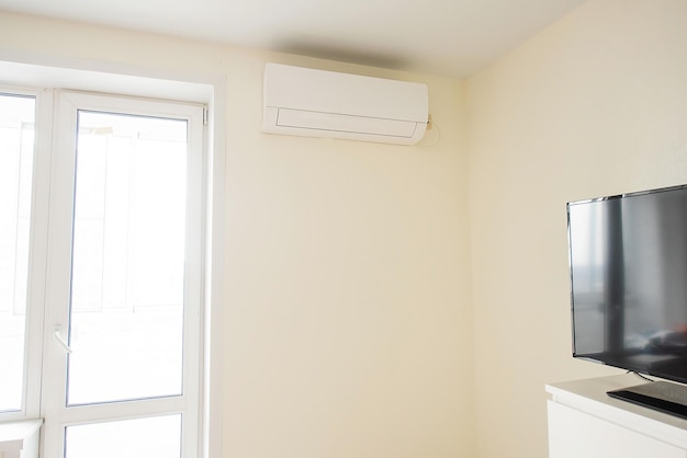 El acondicionador de aire está instalado en la esquina de la habitación real al lado de la puerta del balcón El interior del dormitorio.