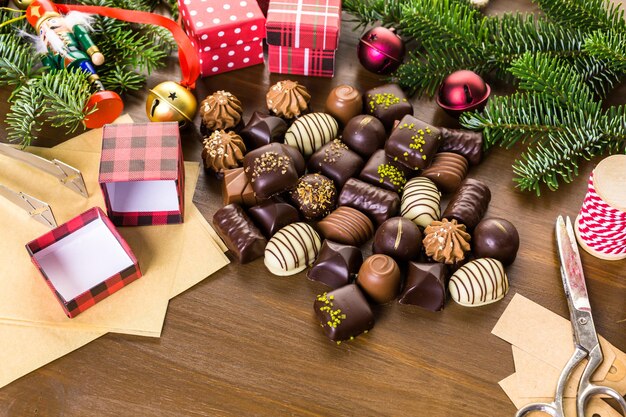 Acondicionar chocolates variados em caixinhas para os presentes de natal.