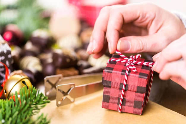 Acondicionar chocolates variados em caixinhas para os presentes de Natal.