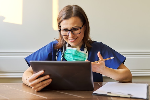 Aconselhamento médico feminino, ajudando o paciente on-line, médico usando tablet digital para chamada de vídeo. Tecnologia, medicina, saúde, conceito de pessoas