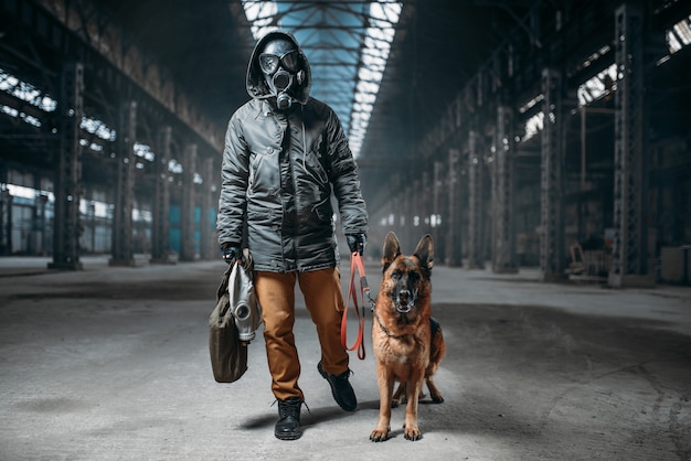 Acosador con máscara de gas y mascota en edificio abandonado, sobrevivientes después de la guerra nuclear. Mundo postapocalíptico. Estilo de vida post-apocalipsis en ruinas, día del juicio final, día del juicio