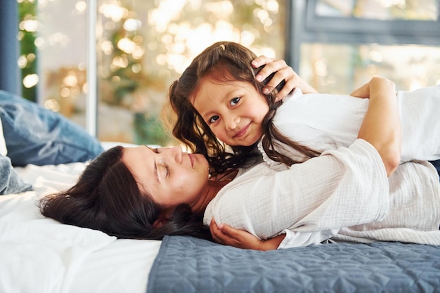 Acostada en la cama Madre e hija pasando tiempo juntas en casa