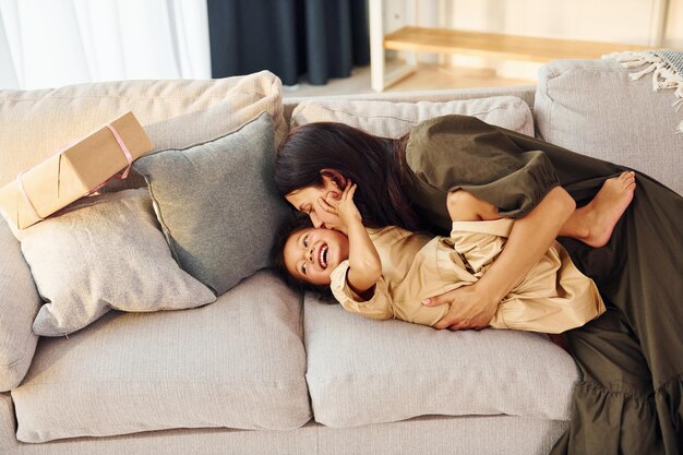 Acostada en la cama Madre e hija pasando tiempo juntas en casa