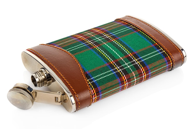 Acostado petaca de peltre escocesa clásica con adornos de cuero y tartán aislado en blanco