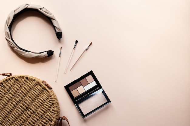 Foto acostado plano con accesorios para mujer y espacio de copia diadema de sombra de ojos o aro para el cabello y bolso de mujer