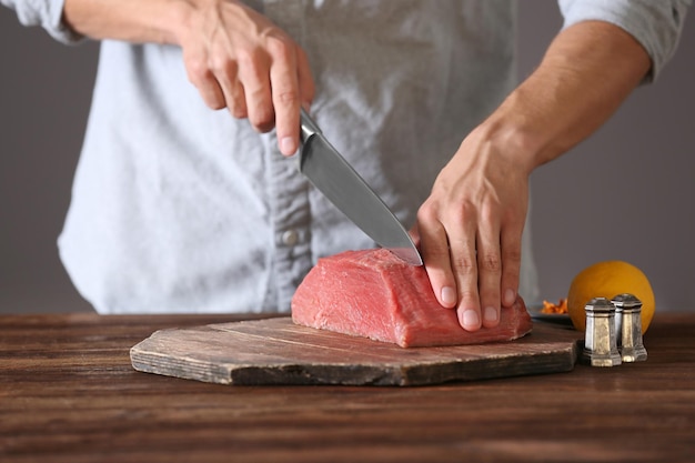 Açougueiro cortando carne de porco na cozinha