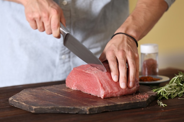 Açougueiro cortando carne de porco na cozinha