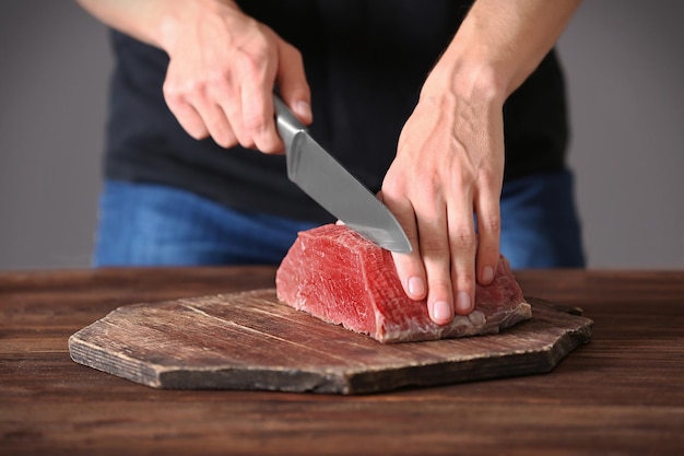 Açougueiro cortando carne de porco na cozinha