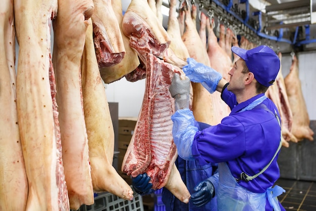 Açougueiro cortar carne de porco na fabricação de carne.