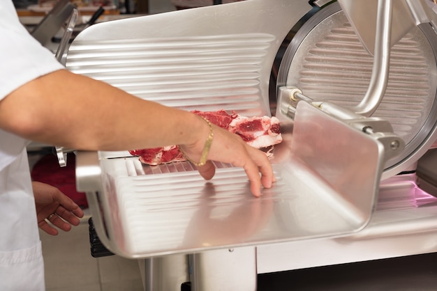 Foto açougueiro cortar carne no açougue. fechar-se