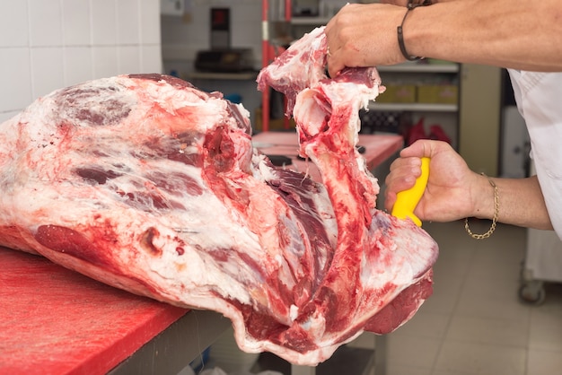 Açougueiro cortar carne no açougue. Fechar-se