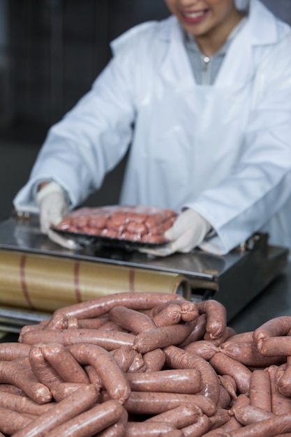 Foto açougueiro embalagem salsichas cruas