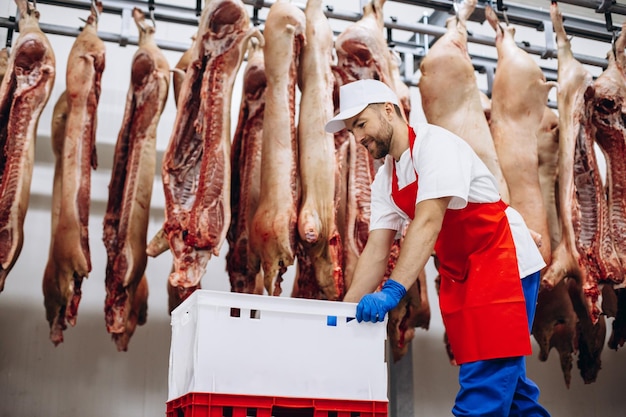 Foto açougueiro empurrando caixas no freezer de carne