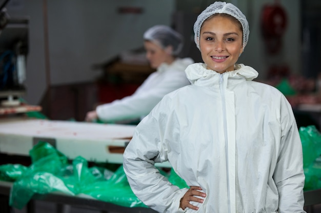 Açougueiro feminino em pé com as mãos no quadril