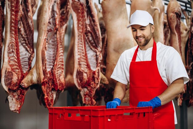 Foto açougueiro no freezer com caixa cheia de carne