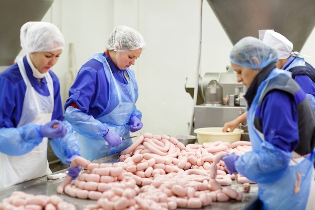 Açougues processando salsichas na fábrica de carne.