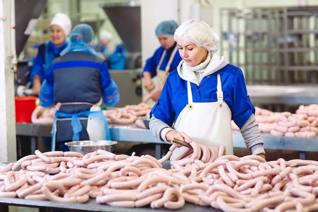 Açougues processando salsichas na fábrica de carne.