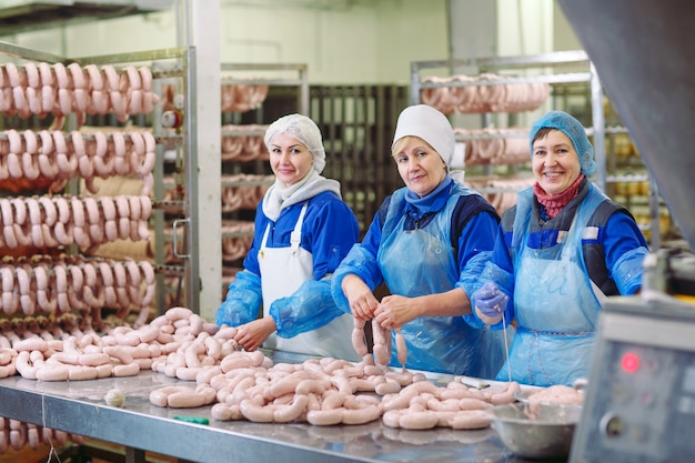 Foto açougues processando salsichas na fábrica de carne.