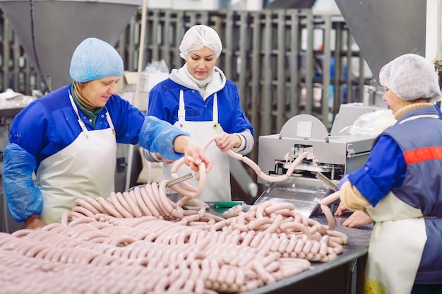 Açougues processando salsichas na fábrica de carne.