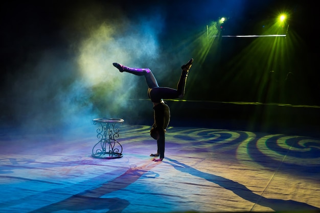 Foto acrobat führt einen schwierigen trick im zirkus aus.