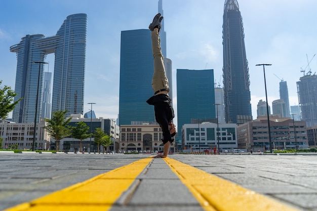 Acrobat hält mit dem verschwommenen Stadtbild von Dubai das Gleichgewicht in den Händen