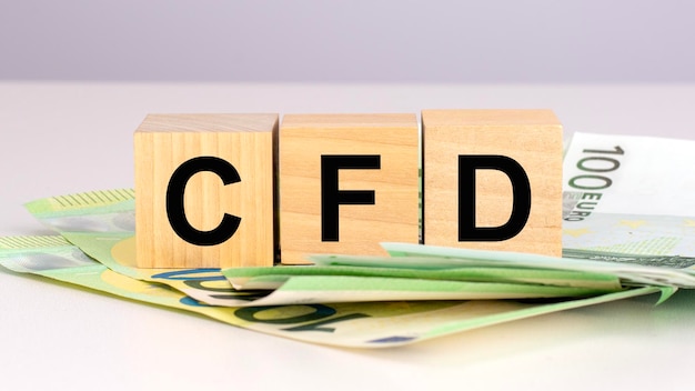 Acrónimo CFD Contracts For Difference texto sobre cubos de madera con billetes de euro