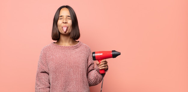 con actitud alegre, despreocupada, rebelde, bromeando y sacando la lengua, divirtiéndose