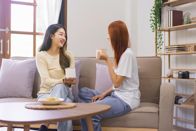 Actividad en casa concepto LGBT lesbiana sentada en el sofá y tomando café mientras hablan juntos