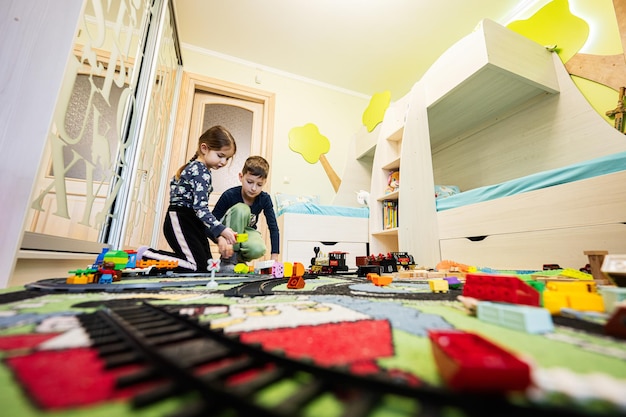 Actividad de ocio infantil juego creativo Los niños juegan en casa con tren de juguete