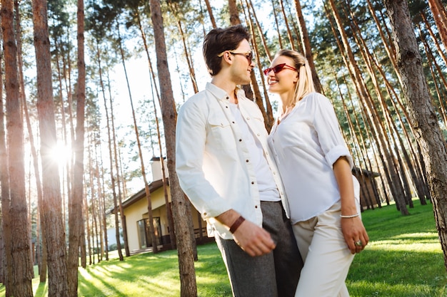 Actividad recreacional. Alegre pareja feliz sonriendo mientras da un paseo por el bosque