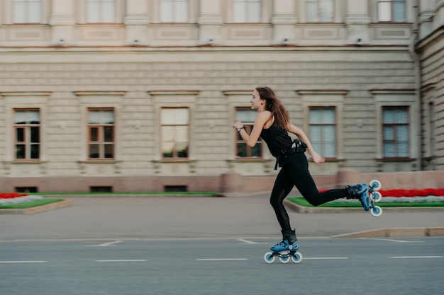 Actividades físicas al aire libre. Una mujer joven y saludable tiene una figura delgada, lleva un estilo de vida activo y pasa tiempo libre al aire libre en patines