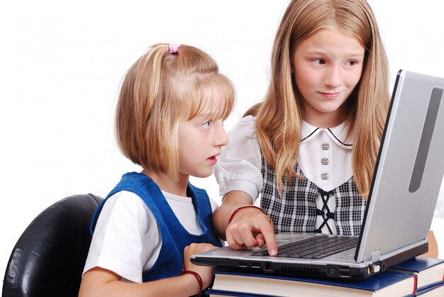 Las actividades de los niños en la computadora portátil ponen en el escritorio, aislado