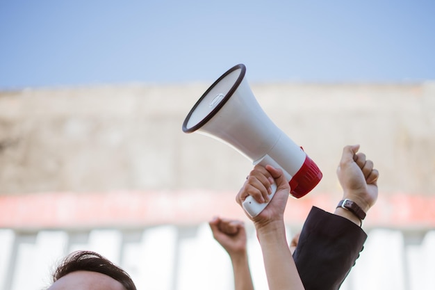 Un activista está elevando apasionadamente su voz con un megáfono en una reunión de protesta