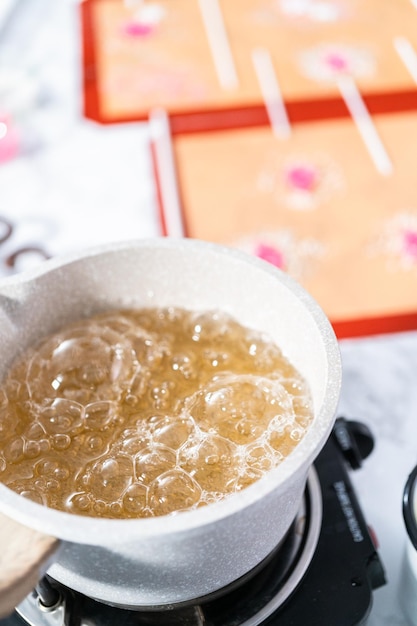 Foto açúcar caramelizado na panela para fazer pirulitos caseiros.