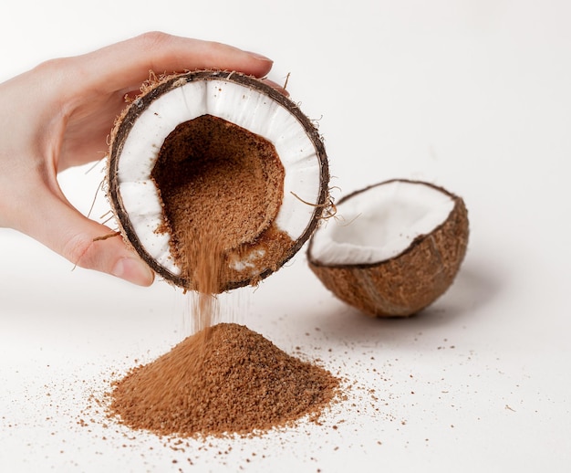 Açúcar de coco derramando de frutas de coco