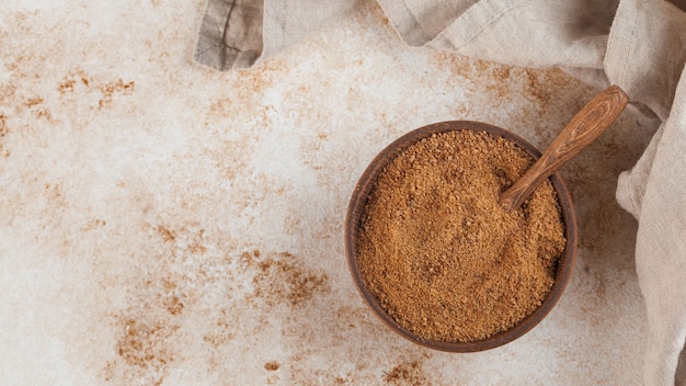 Açúcar de coco em uma tigela de madeira com uma folha de palmeira