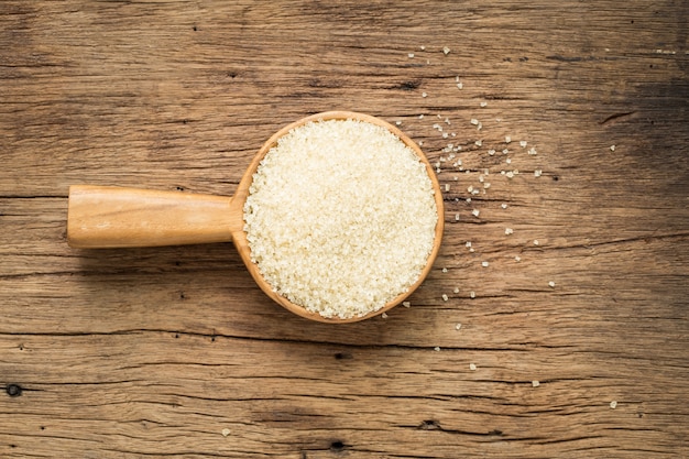 Açúcar em uma colher de pau em uma mesa de madeira velha