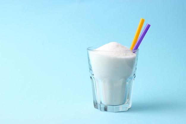 Açúcar refinado em um copo em um fundo colorido conceito de diabetes excesso de açúcar