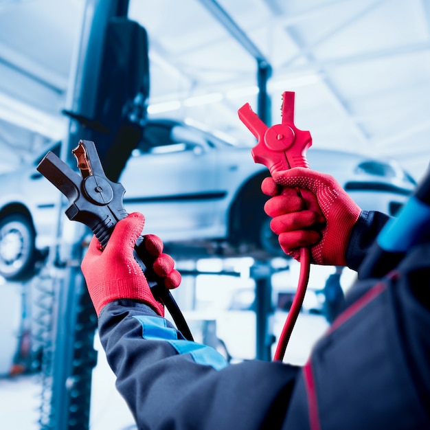 Acumulador de carga. Manos y terminales. Reparación de autos.