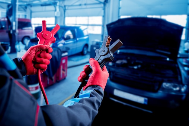 Acumulador de carregamento. mãos e terminais. reparo de carros.