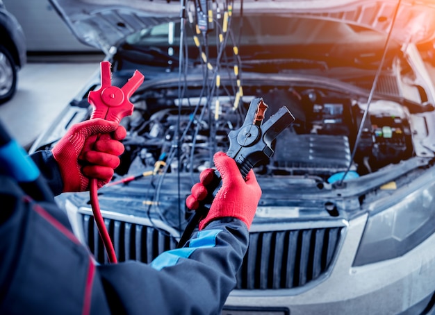 Acumulador de carregamento. Mãos e terminais. Reparo de carros.