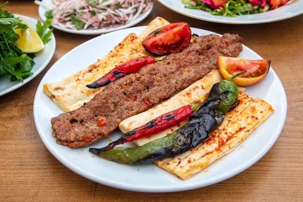 Adana Kebab im türkischen Stil. Traditionelles türkisches Essen Adana Kebab auf Holztisch.