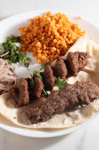 Adana Kebab turco con verduras en el plato