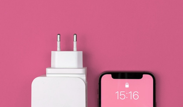 Foto adaptador de cargador usb para smartphone. tipo ue. fondo rosa, plano, vista superior y espacio de copia.