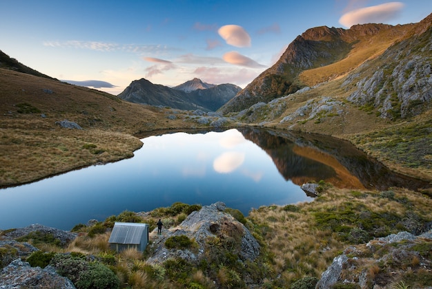 Adelaide Tarn y cabaña con tramper Parque Nacional Kahurangi Nueva Zelanda